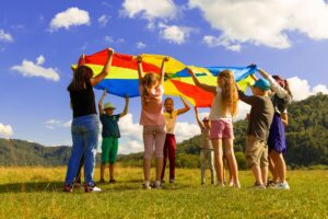 A group of kids standing in a circle on a field.