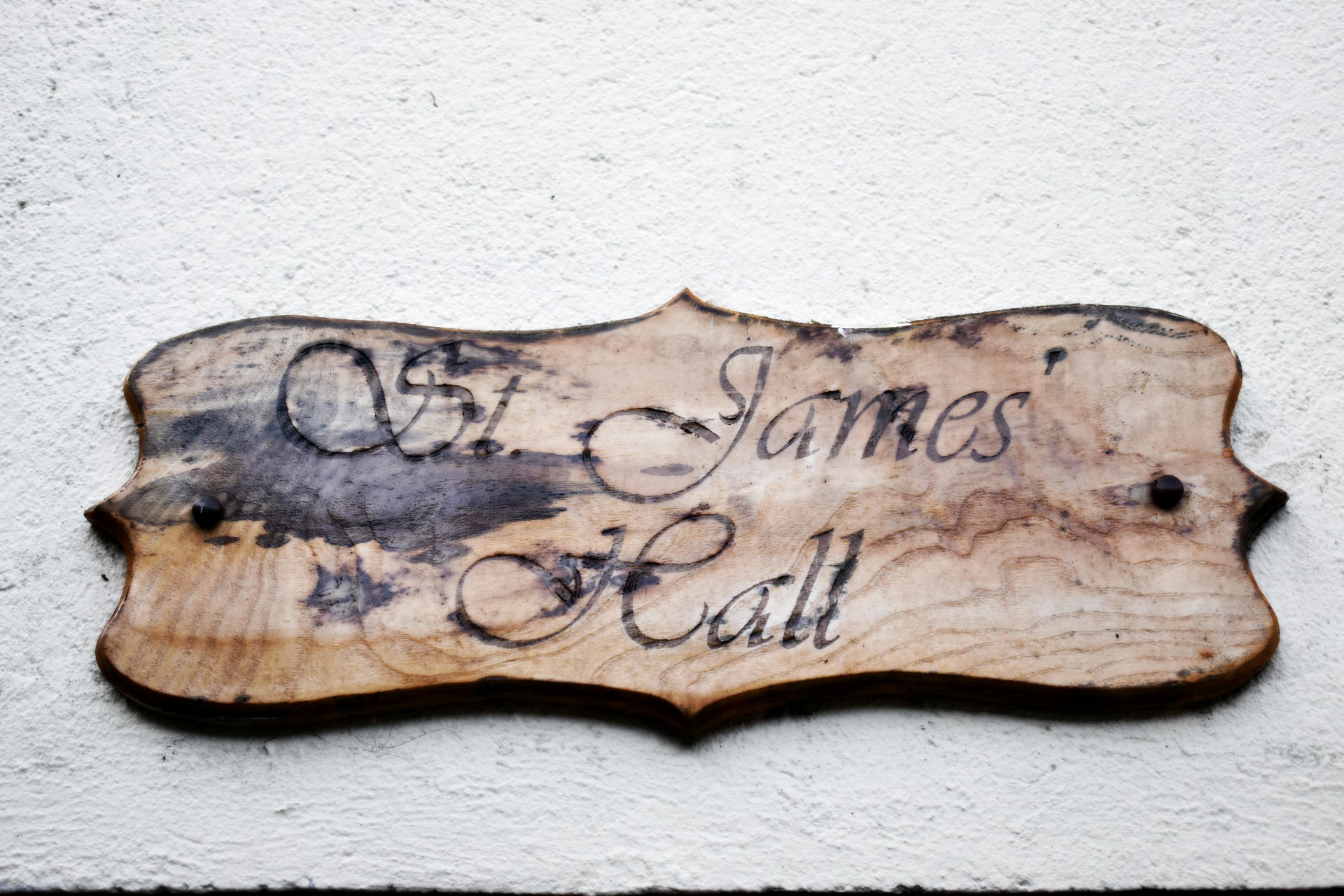 A wooden sign displaying 'St. James' Hall'.