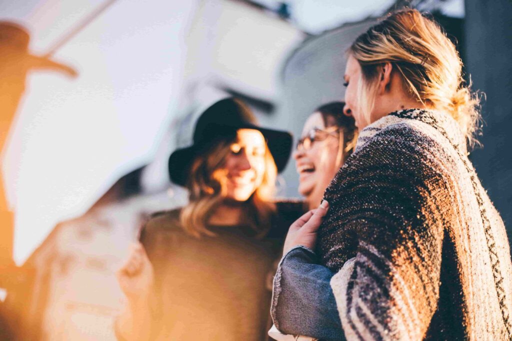 A group of women engaged in conversation, sharing laughter.