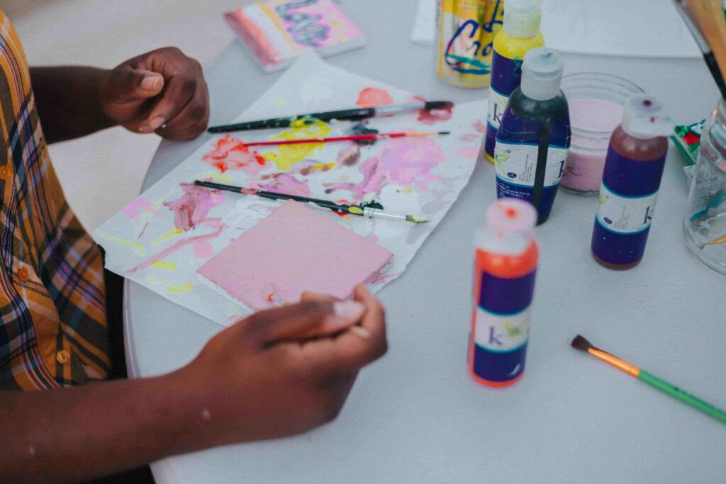 A child painting with paint and supplies.