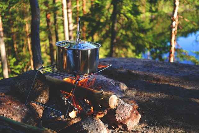 A pot on a campfire with a metal pot on top, cooking food outdoors.