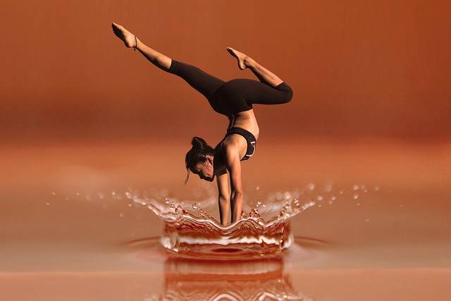 A woman gracefully performs a handstand on the surface of water, showcasing her yoga skills.