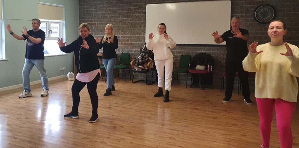 A diverse group of individuals practicing tai chi.