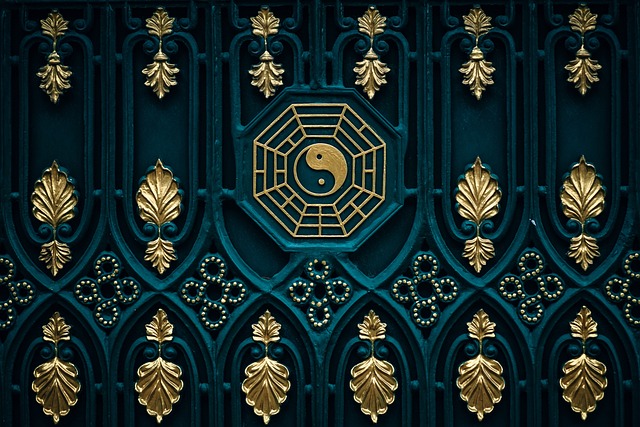 Golden gate with intricate ornate design featuring yin and yang golden ornaments on a lush green background.