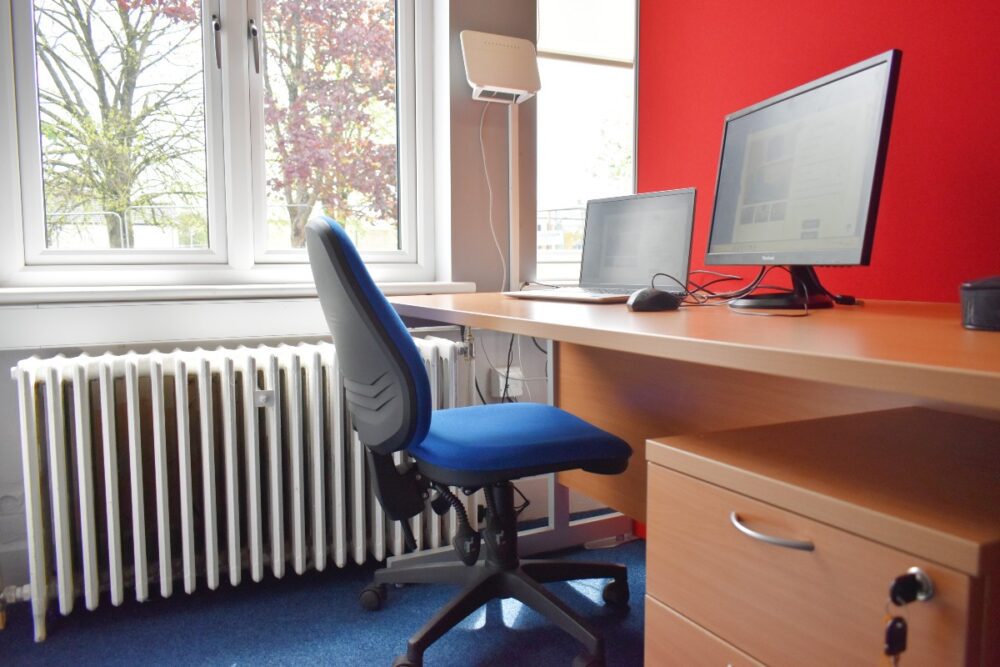A hot desk in an office with a computer and chair.