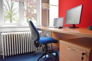 A hot desk in an office with a computer and chair.