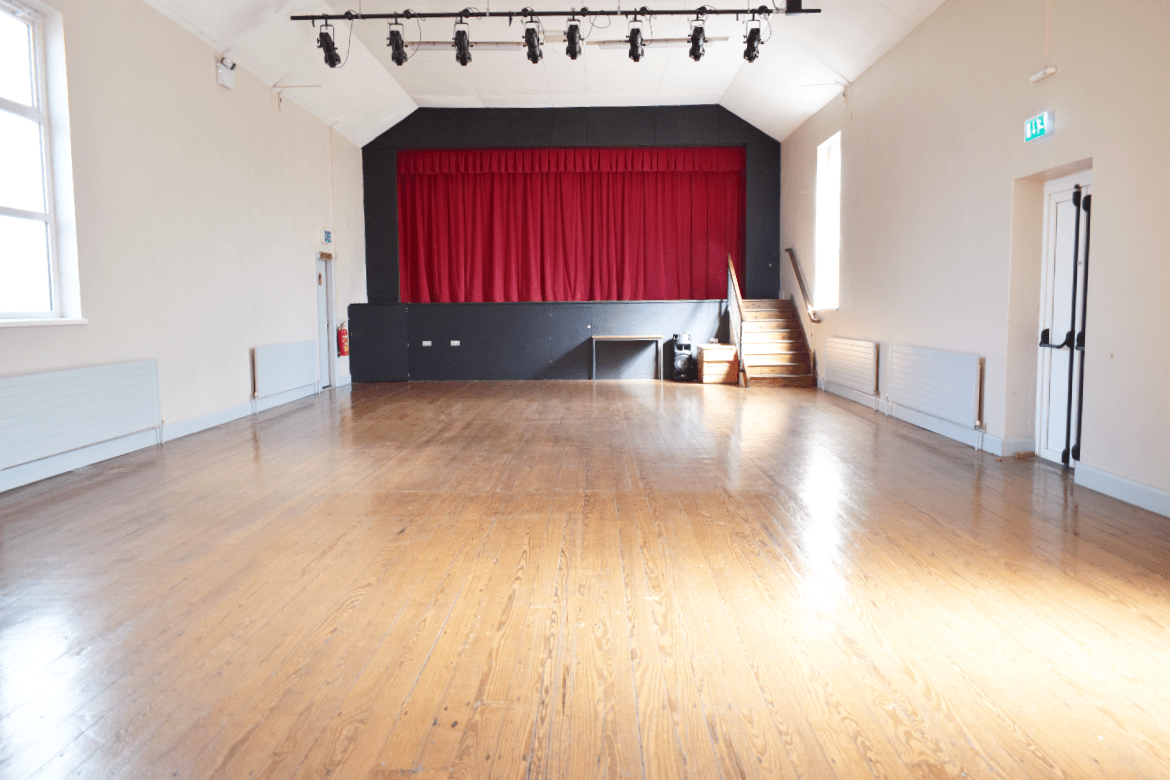 Spacious room with red curtain on stage