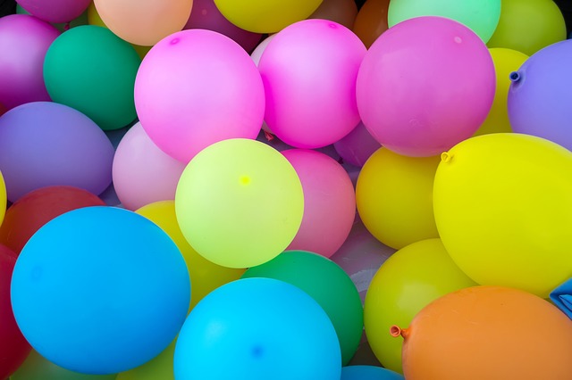 Bright balloons of various colors fill the image, adding a festive touch.