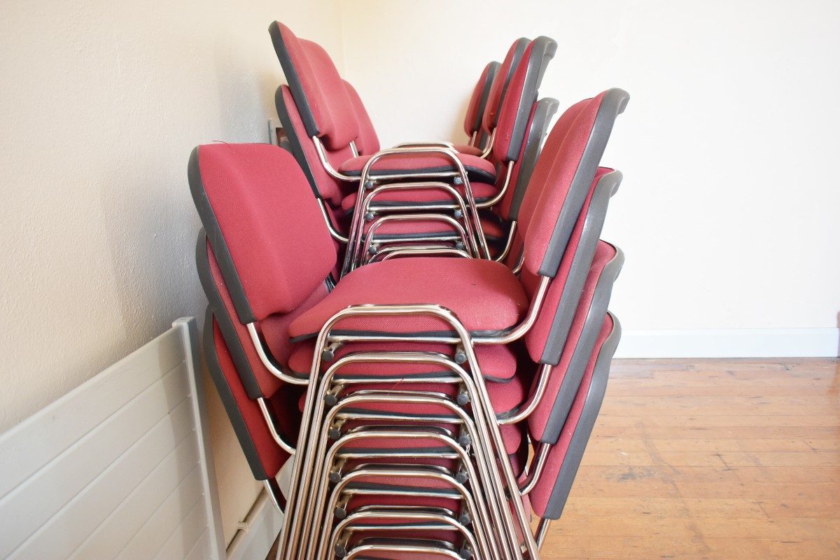 Red chairs stacked neatly on top of each other.