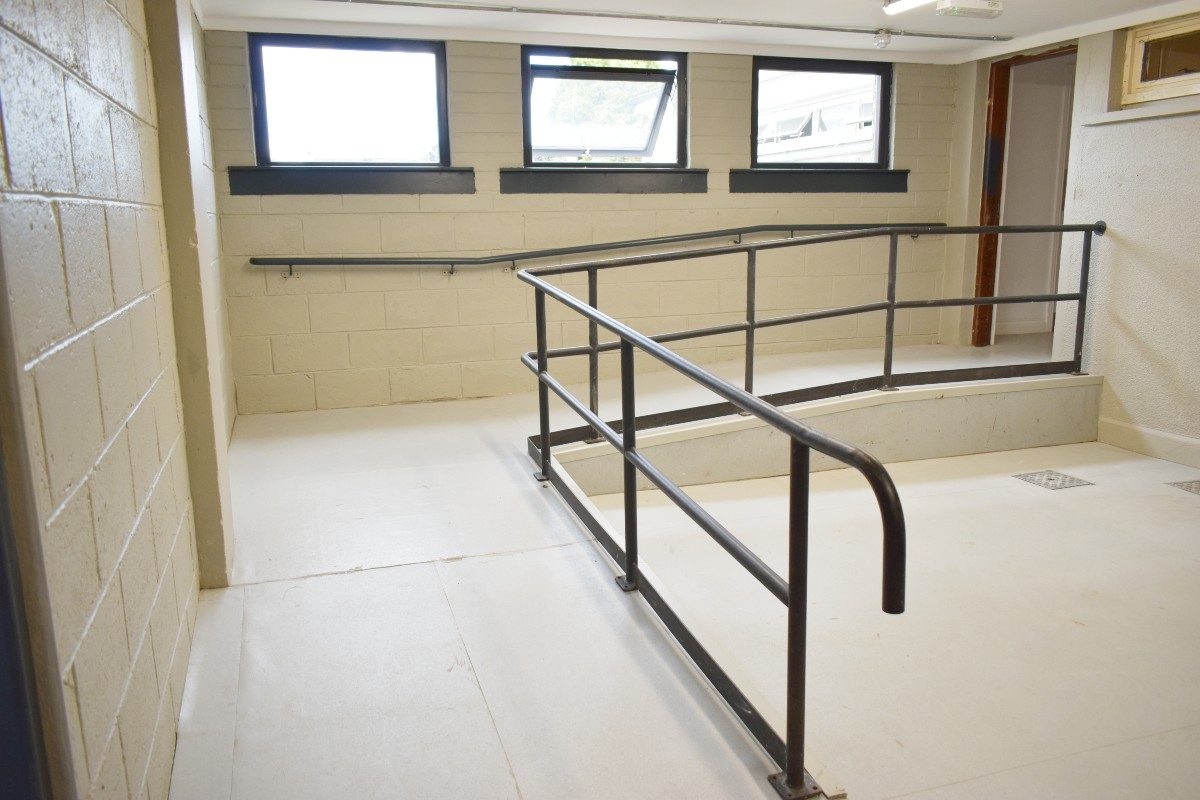 A wheelchair accessible stairway with railing and window at Athboy CCC Hall.