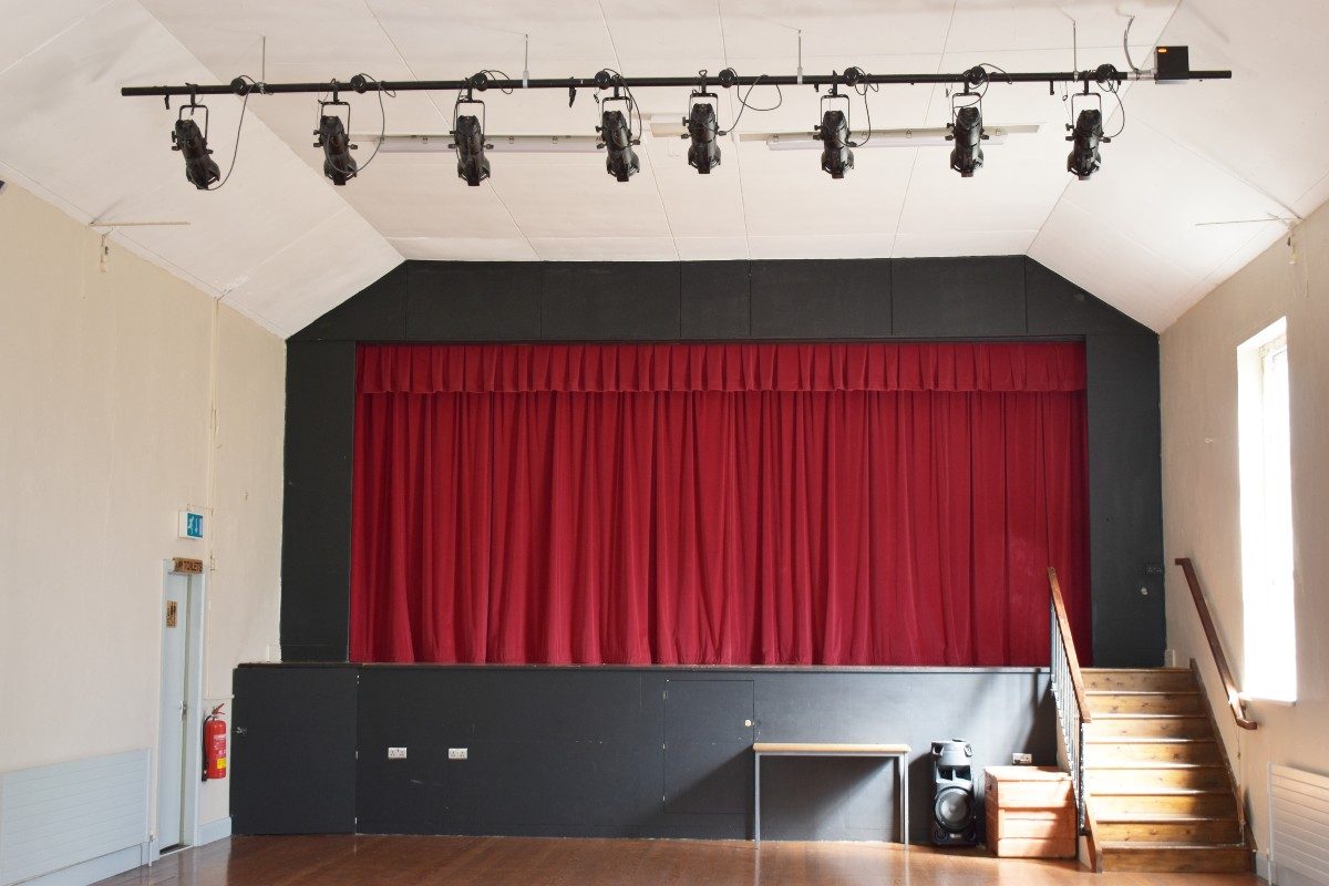 Spacious room with red curtain on stage