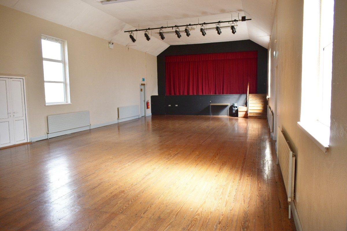 Spacious room with red curtain on stage