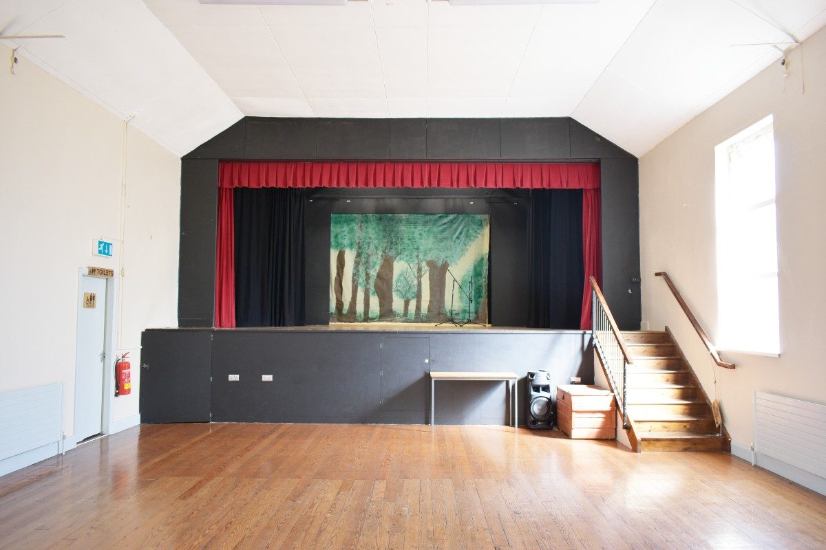 Spacious room with red curtain on stage