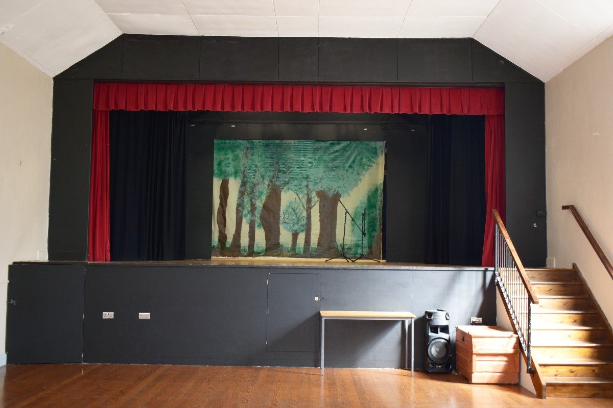 Spacious room with red curtain on stage