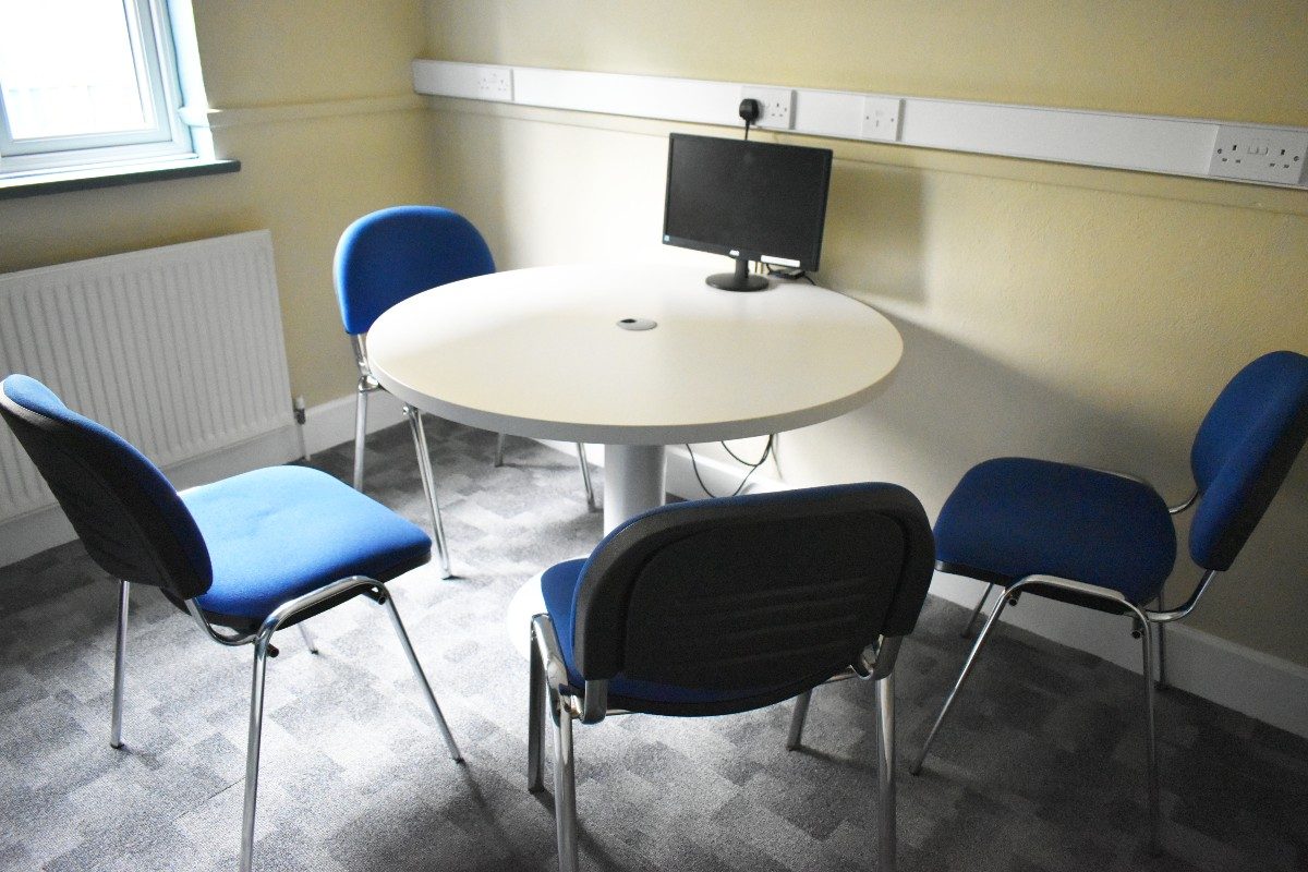 A resource room table with four chairs for collaborative work or meetings.