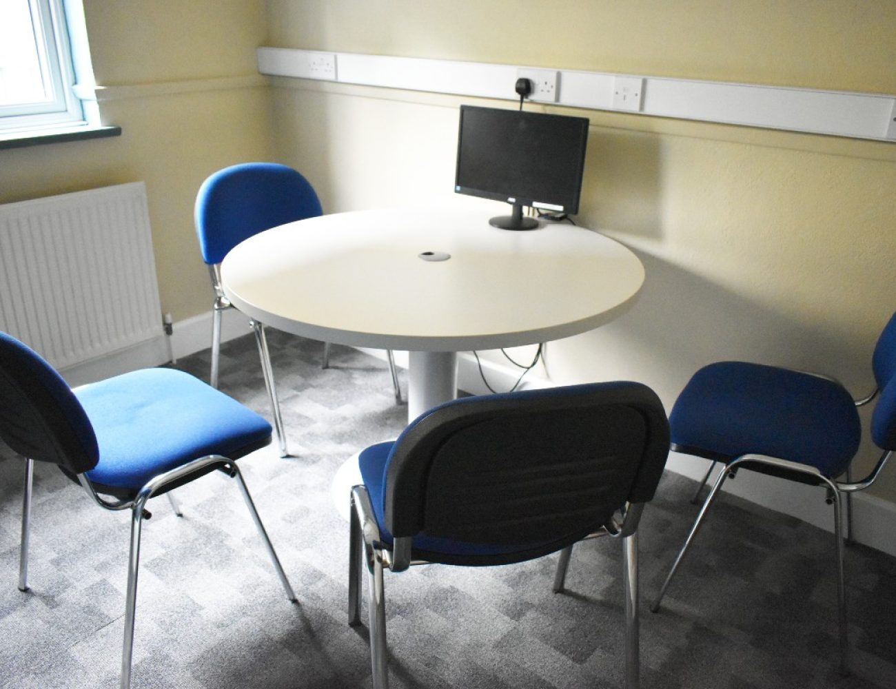 A resource room table with four chairs for collaborative work or meetings.