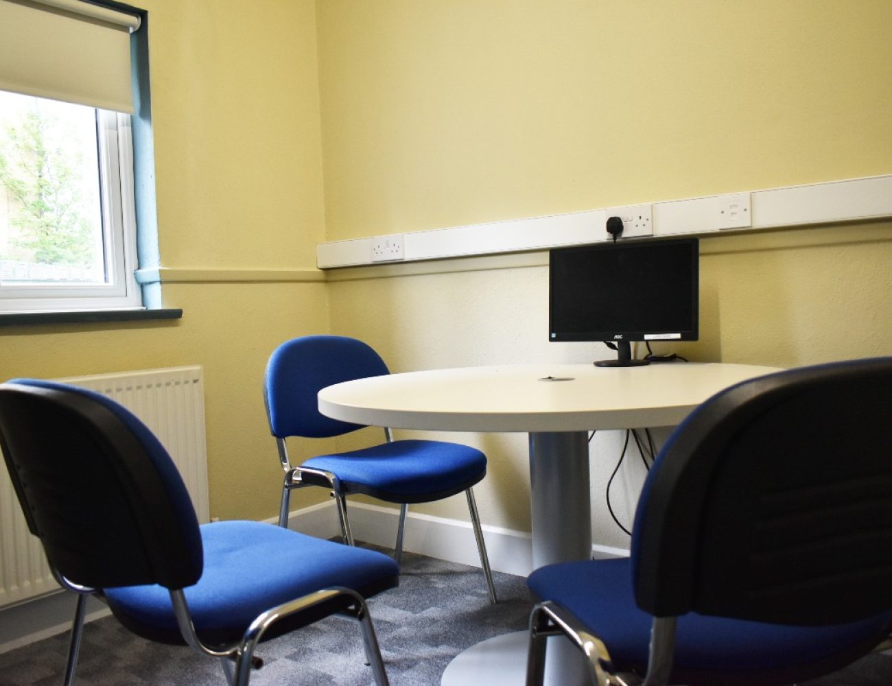 A resource room table with four chairs for collaborative work or meetings.