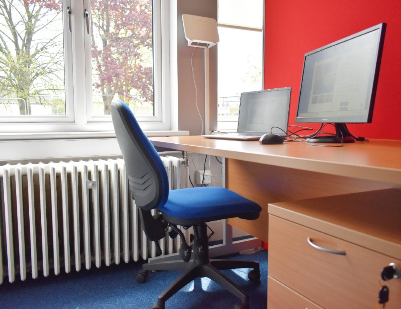 A hot desk in an office with a computer and chair.