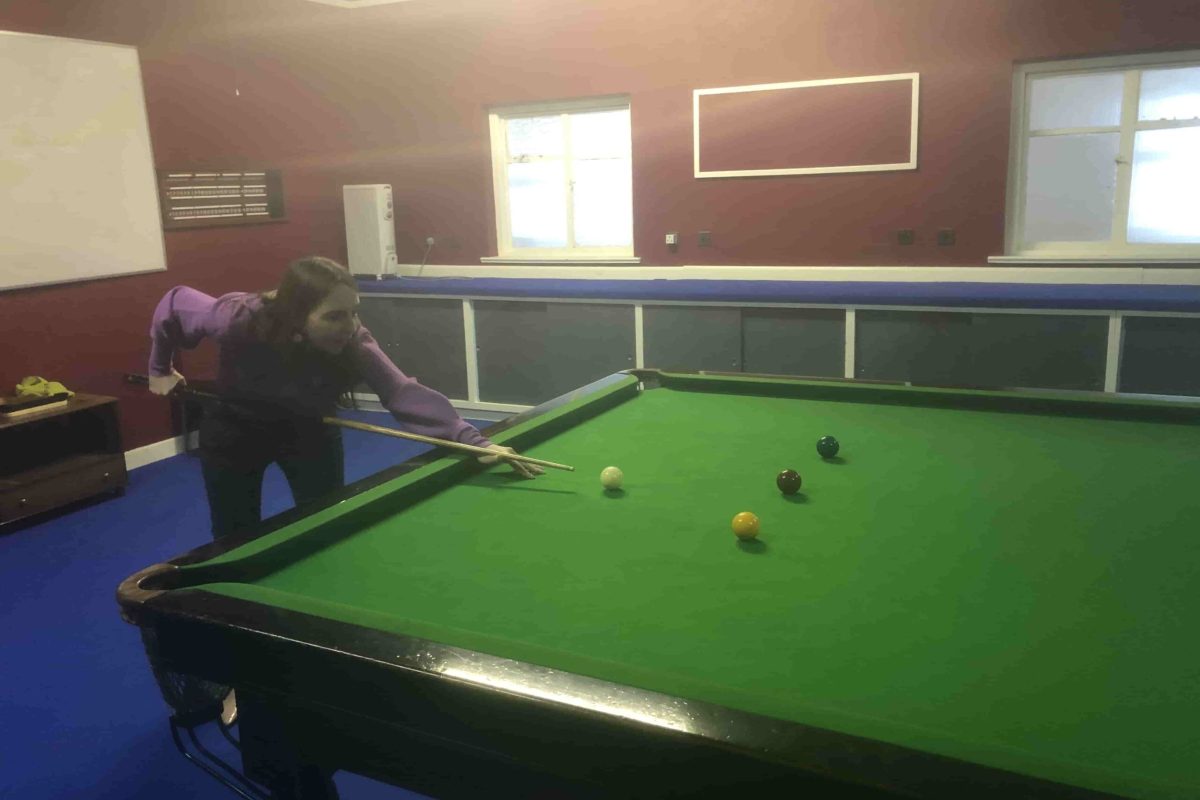 A person playing pool in a room.