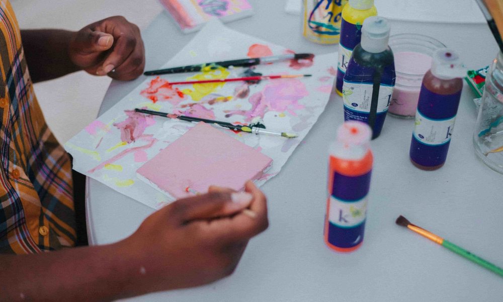 A child painting with paint and supplies.