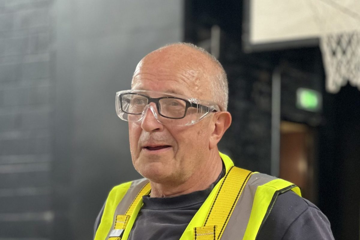 A man with safety glasses and a vest.